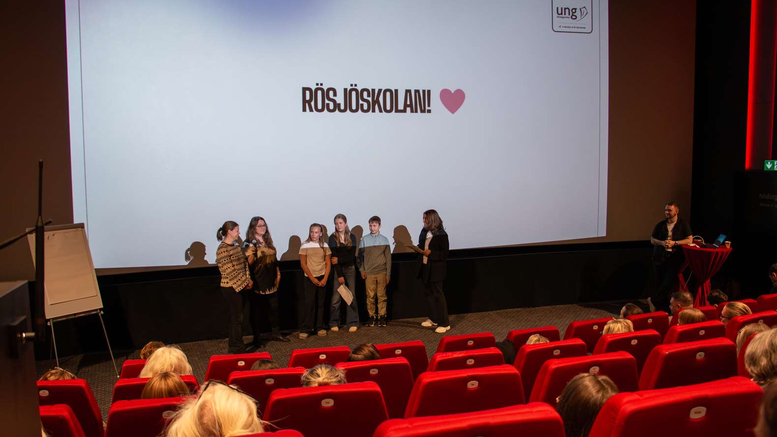 Elever och lärare talar inför publik